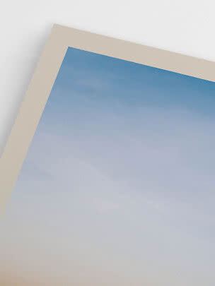 Close-up van de hoek van een print met blauwe luchtverloop en brede crèmekleurige rand