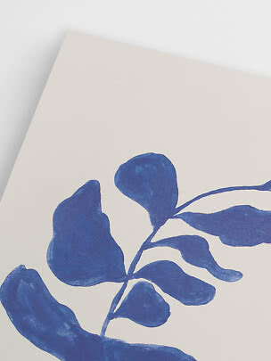 Close-up of a cream poster with blue botanical leaf illustration
