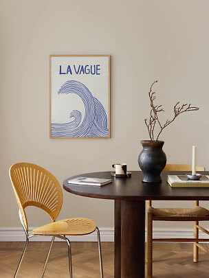 Framed poster with blue wave and "LA VAGUE" text above a dining table
