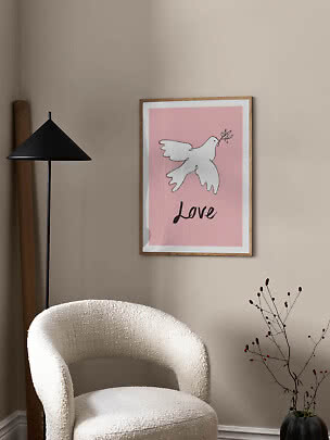 Inramad rosa poster med vit duva och texten ”Love” på en beige vägg