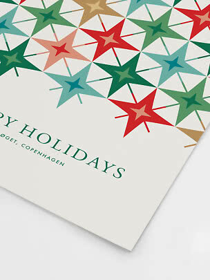 Carta regalo con motivo di stelle colorate rosse, verdi, blu e oro su sfondo bianco