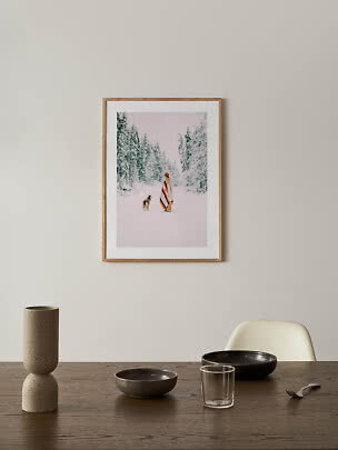 Photo d’hiver encadrée au mur au-dessus d’une table avec vase, bols et verre