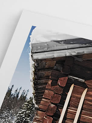 Poster mit Nahaufnahme einer schneebedeckten Holzhütte mit Skiern an der Wand