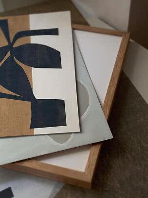 Abstrakt kunstprint i sort, beige og hvid oven på trærammede lærreder