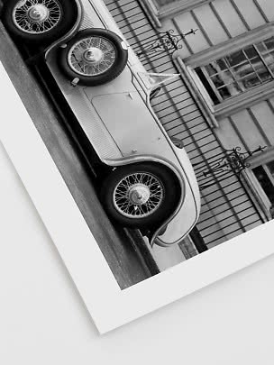 Photo en noir et blanc d’une voiture classique garée devant un bâtiment