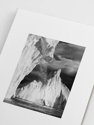 Stampa fotografica in bianco e nero di enormi iceberg sul mare sotto un cielo drammatico