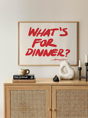 Affiche typographique encadrée avec texte rouge « WHAT'S FOR DINNER? » au-dessus d'un meuble en bois