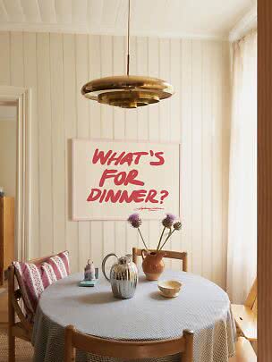 Suspension en laiton au-dessus d’une table ronde avec nappe à carreaux, vase et affiche