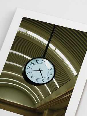 Ronde hangklok aan het plafond onder gebogen ribben in een modern interieur