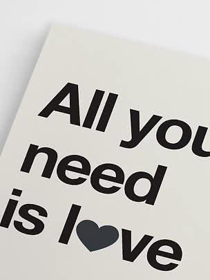 Närbild av typografisk poster med svart text på vit bakgrund och ett mörkt hjärta