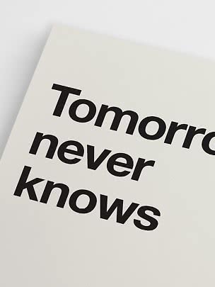 Primo piano di poster bianco con tipografia nera "Tomorrow never knows"