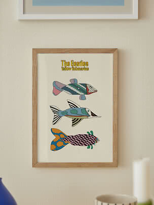 Poster incorniciato dei Beatles Yellow Submarine con tre pesci colorati su parete chiara