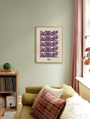 Gerahmtes Beatles-Love-Poster über grünem Sofa in gemütlichem Wohnzimmer am Fenster