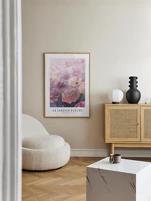 Framed floral poster in pink tones on a beige wall above a light wood cabinet