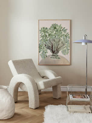 Living room with cream lounge chair, floor lamp and framed botanical wall art