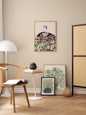 Angolo minimalista con sedia in legno, tavolino e stampe botaniche incorniciate su parete beige