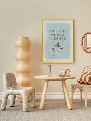 Kids' room with framed poster, round table, chair, paper floor lamp and polka dot mug