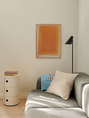 Minimalistisk stue med grå sofa, beige pude, sort gulvlampe og orange abstrakt vægkunst.