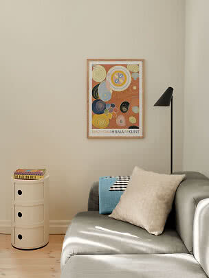Poster incorniciato di Hilma af Klint con spirali astratte su parete beige sopra divano grigio
