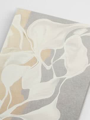 Close-up of wallpaper with large white flowers on a beige and gray background