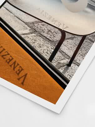 Primer plano de una foto impresa con silla beige, suelo de piedra y alfombra naranja con texto
