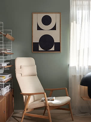 Abstracte poster met zwarte geometrische vormen in houten lijst aan groene muur