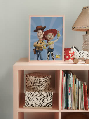 Poster Toy Story incorniciato con Woody e Jessie su uno scaffale rosa in cameretta