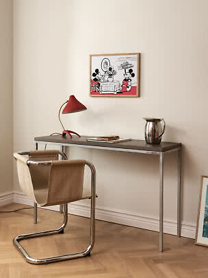 Schreibtisch aus Metall und Holz mit roter Tischlampe, Stuhl und gerahmtem Mickey-Mouse-Bild