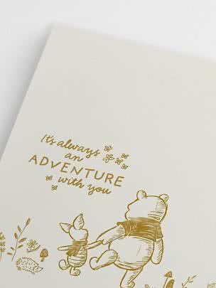 Tarjeta blanca con ilustración dorada de Winnie the Pooh y Piglet y texto "It's always an adventure with you"