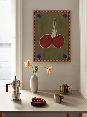 Póster enmarcado de cerezas sobre una mesa con jarrón, cafetera, taza y tomatitos
