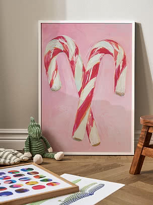 Indrammet plakat med malede sukkerstokke i pink, rød og hvid mod lyserød baggrund
