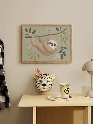 Poster incorniciato con una dolce illustrazione di bradipo appeso a un ramo tra foglie