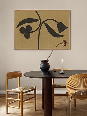 Botanisk plakat i liggende format i egetræsramme over et rundt spisebord med vase og lys
