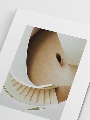 Close-up of the unframed print at an angle, showing the staircase, the blurred figure and the matte paper surface