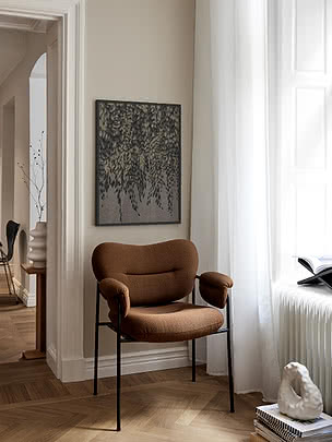 Stampa Cascading Foliage in cornice scura su parete beige sopra una poltrona in velluto cognac accanto a una finestra