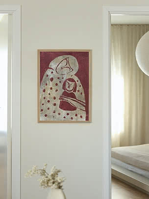 Tirage Mother and Child dans un cadre en chêne sur un mur d'entrée clair au-dessus d'un vase blanc de fleurs séchées