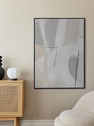 Trykket Subtle Calm i sort ramme på en beige væg over et skænk i lys eg med rattanlåger og en hvid kuglelampe