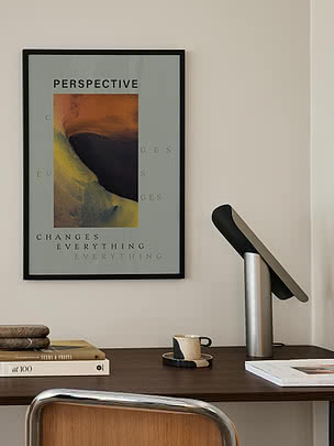 Druck Perspective im schwarzen Rahmen an cremefarbener Wand über einem Nussbaumschreibtisch mit schwarz verchromter Leuchte und Büchern