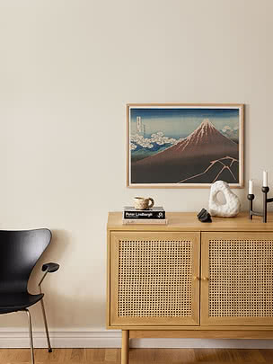 Druck Shower Below the Summit im Eichenrahmen an cremefarbener Wand über einem Sideboard aus heller Eiche mit Rattanfronten und Büchern