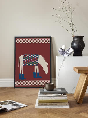 Poster Whimsical Donkey in cornice nera appoggiato a una parete bianco sporco, accanto a un plinto in marmo, libri impilati e una tazza in gres su pavimento a spina