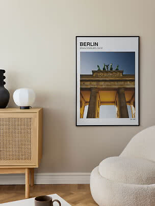 Framed Berlin poster with Brandenburg Gate on a beige wall in a modern living room