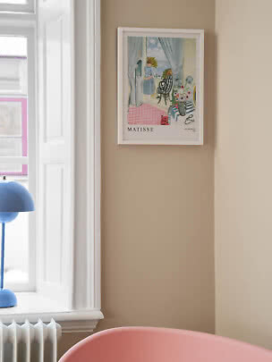 Indrammet Matisse-plakat på beige væg ved hvidt vindue og blå lampe
