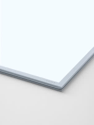 Close-up of a light blue rectangular tabletop or panel corner with rounded edge