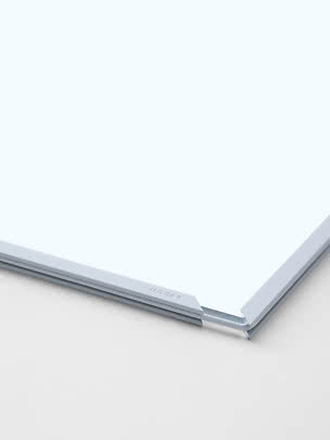 Close-up of white board with aluminum frame and corner bracket