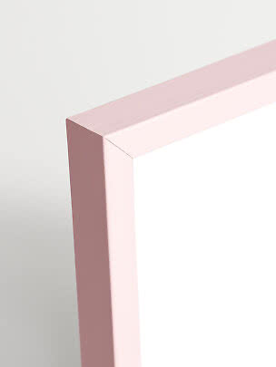 Primo piano dell’angolo di uno specchio con cornice rosa chiaro
