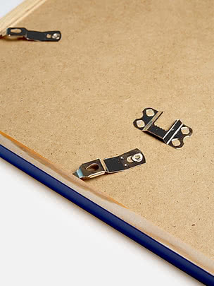 Retro di una cornice quadrata in blu con il pannello posteriore in MDF e gli attacchi metallici per appenderla