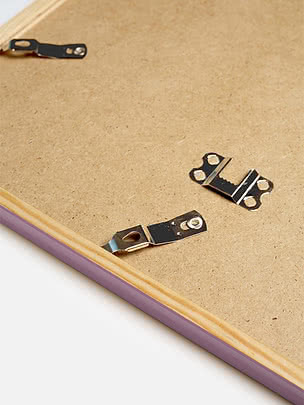 Retro di una cornice quadrata in viola pastello con il pannello posteriore in MDF e gli attacchi metallici per appenderla