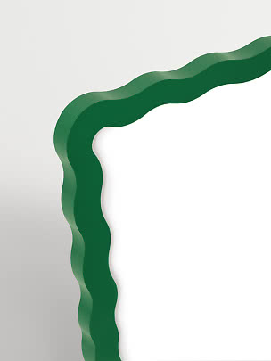 Wavy green mirror frame with an organic shape on a white background