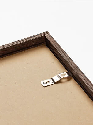 Primo piano del retro di una cornice in legno scuro con gancio metallico
