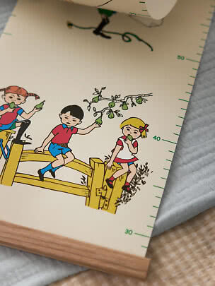 Pippi height chart with colorful illustration of children on a fence, pears and green measuring marks